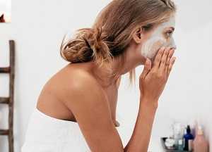 En kvinna applicerar sin ansiktsmask